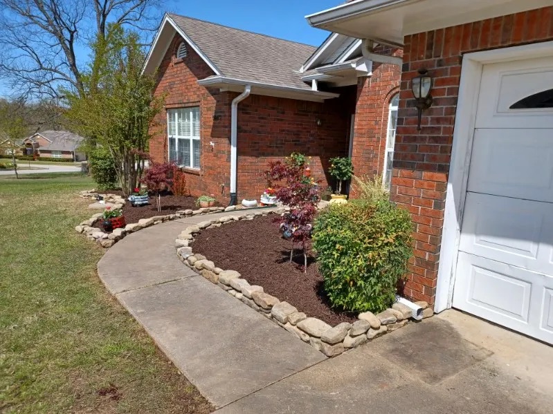 Fresh mulch beds and planting along a brick home
