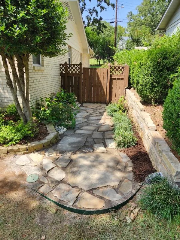 Flagstone walkway beside a stacked stone retaining wall