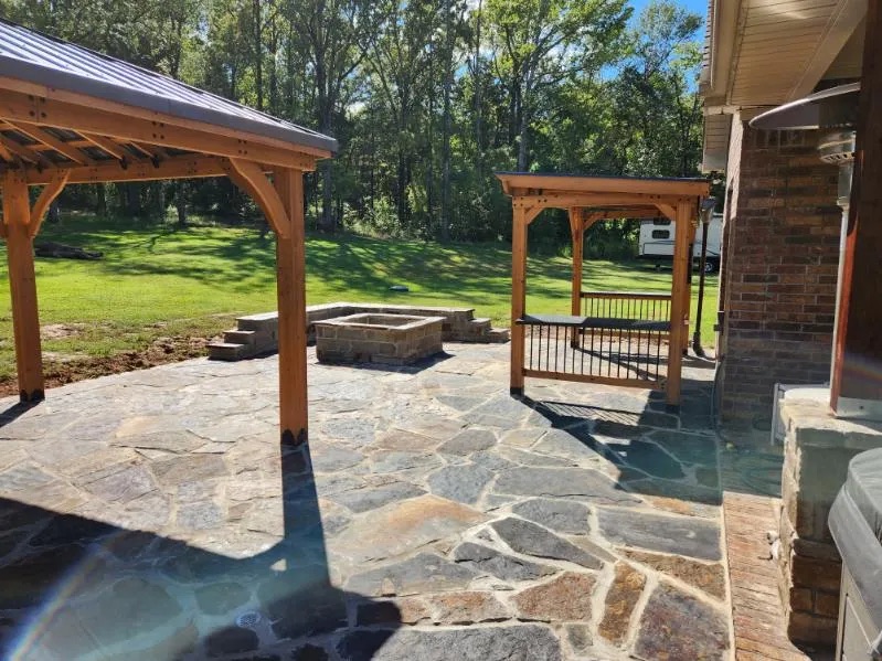 Flagstone patio with a pavilion and fire pit in a River Valley backyard
