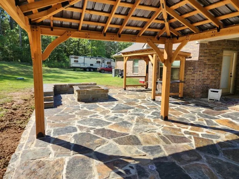 Large flagstone patio with a cedar pavilion and fire pit