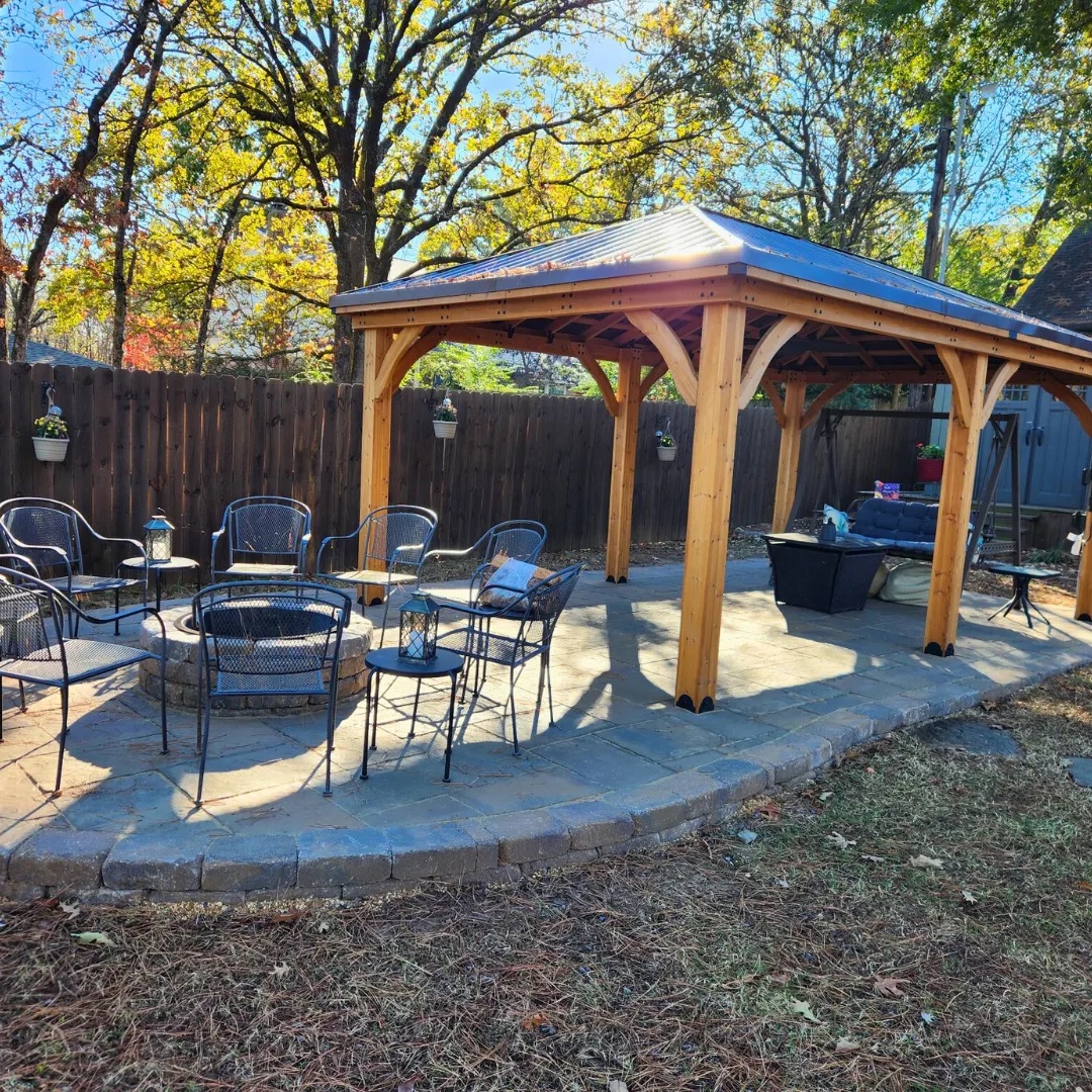 Outdoor lounge area under a pavilion with fall foliage