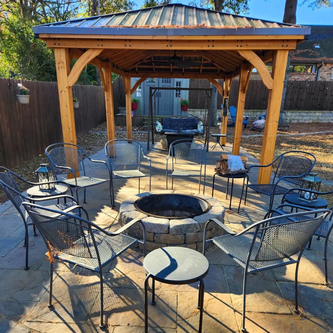 Cedar pavilion with a fire pit ringed by seating on a paver patio
